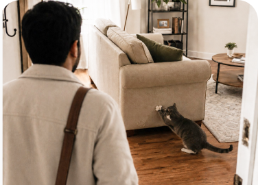 A person sitting on a sofa with a pet nearby