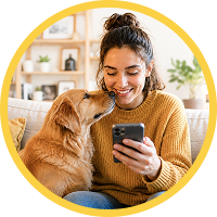 Future pet owner smiling at a dog while checking a phone